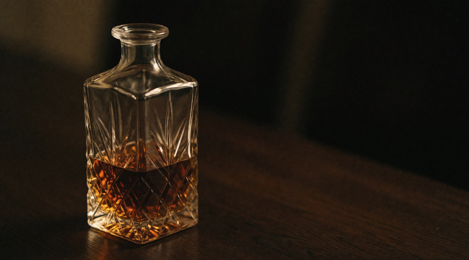 A crystal decanter half full of amber spirit.