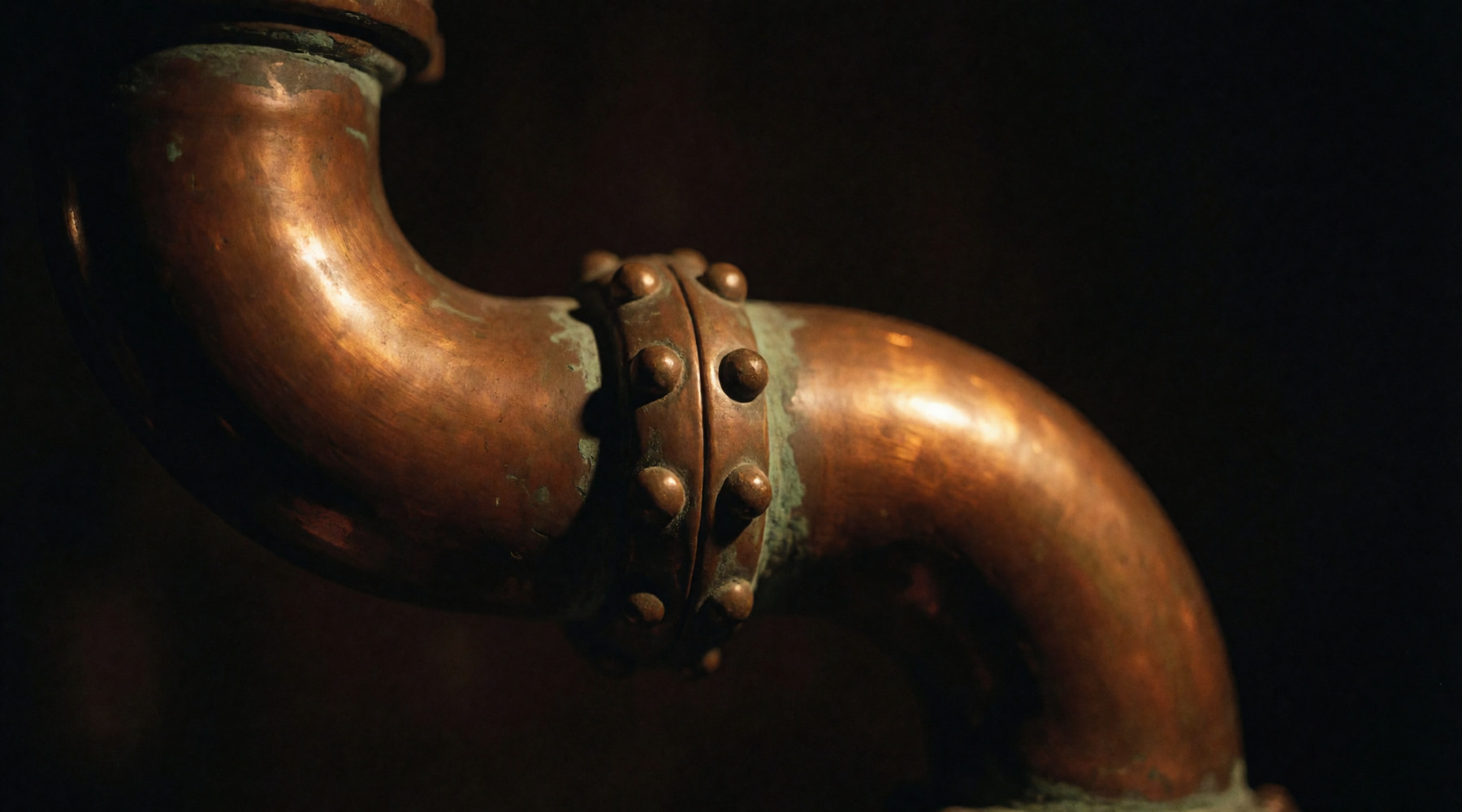 Copper pipework and a riveted joint, close up.